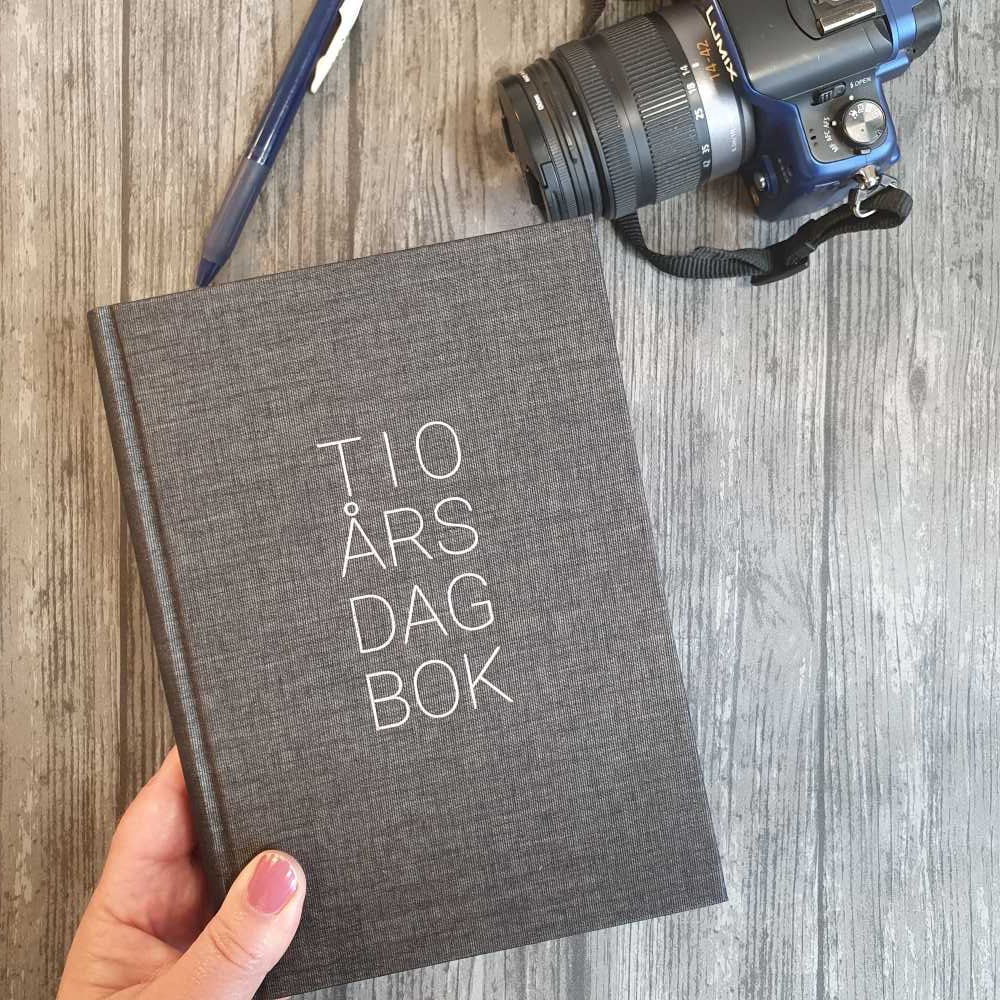 Svart 10-års dagbok med tygklädd pärm. Tidformera