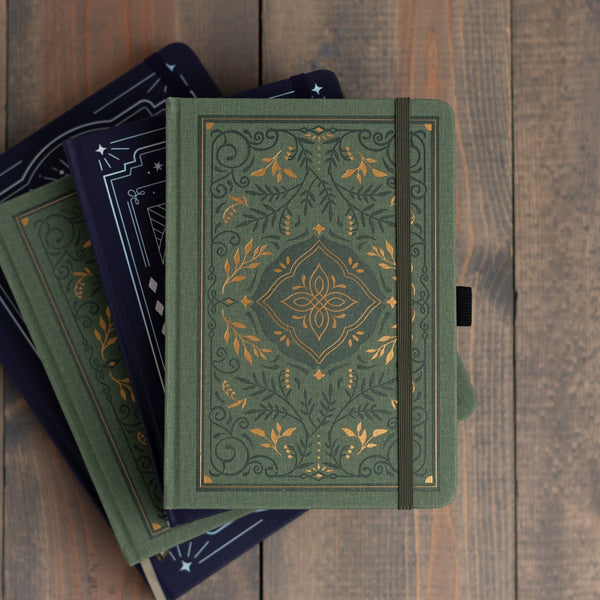 Dotted notebook från Archer & Olive ligger i en trave. Vackra gröna och blå  anteckningsböcker i olika storlekar.  - Tidformera
