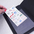 Självhäftande istoppsfickor A6 Pockets från 3L. En hand skjuter in ett ark i en plastficka som är fäst i en skrivbok.  Tidformera