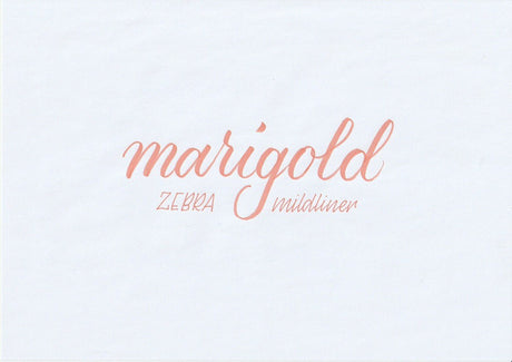 Handskriven text med orden "marigold" och "ZEBRA mildliner" i orange färg, skriven med Zebra Mildliner Brush Pen i färgen Marigold.